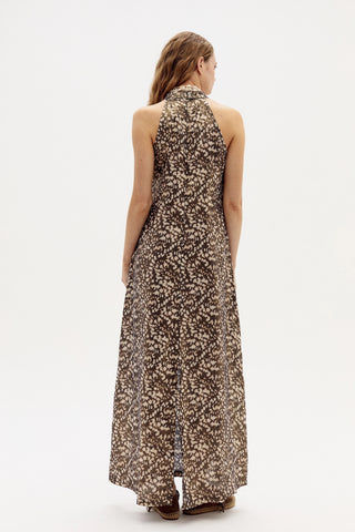 Woman wearing a floral halter neck dress on a white background