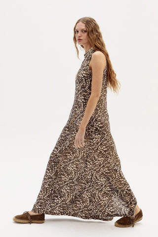 Woman wearing a sleeveless dress with a pattern on a white background
