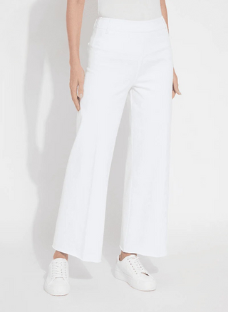 Person wearing white pants and white sneakers on a plain background